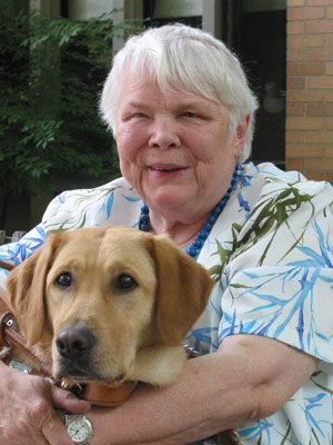 Award-winning author Jean Little photographed holding her dog. 
