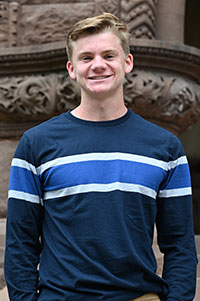 Samuel Thomas Henke standing on building entrance steps.