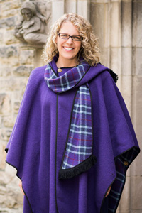 Principal Michelle Voss Roberts posing in front of Emmanuel College. 