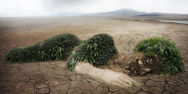 A dirt pile in the desert shaped like a person.